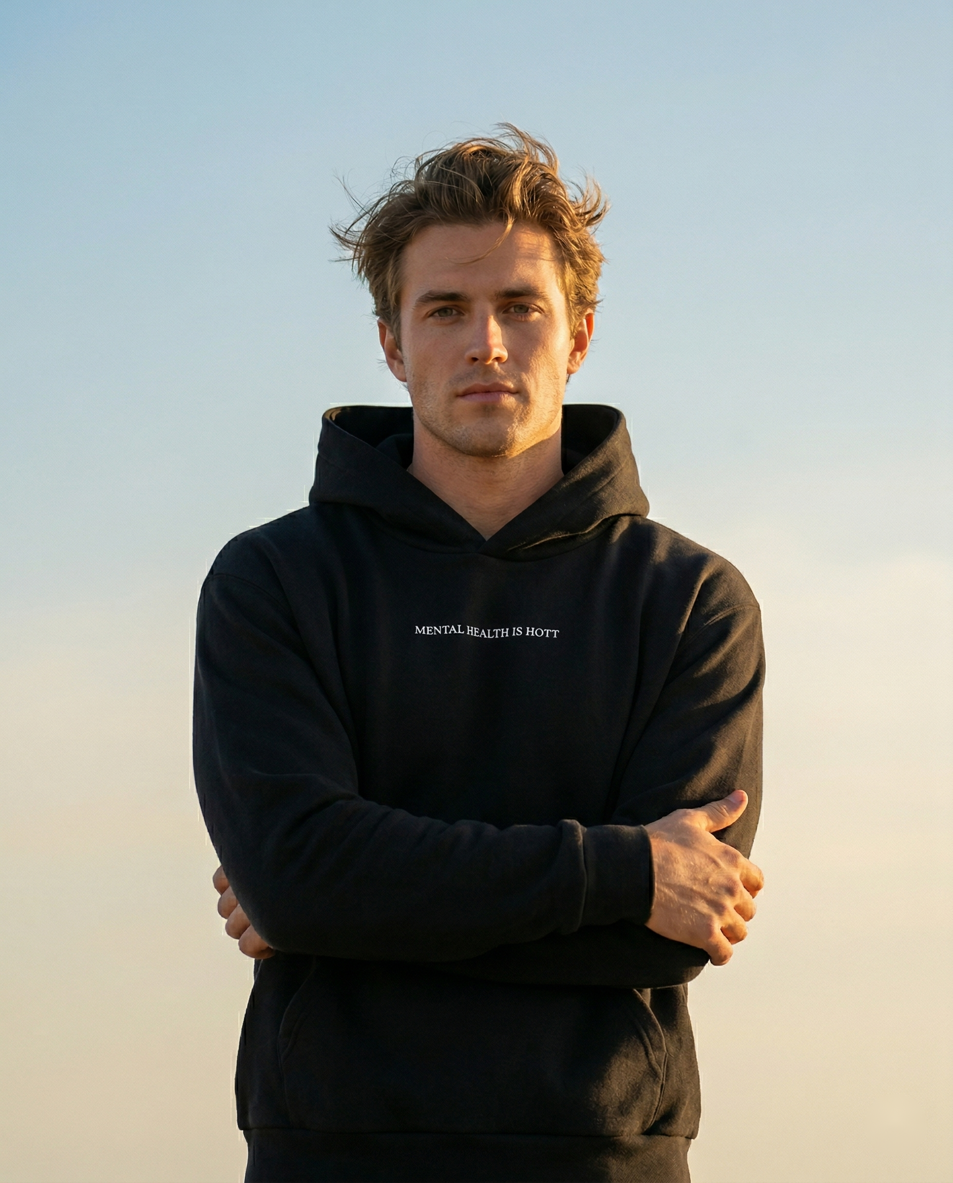 Man wearing the black Mental Health Is Hott hoodie in warm light